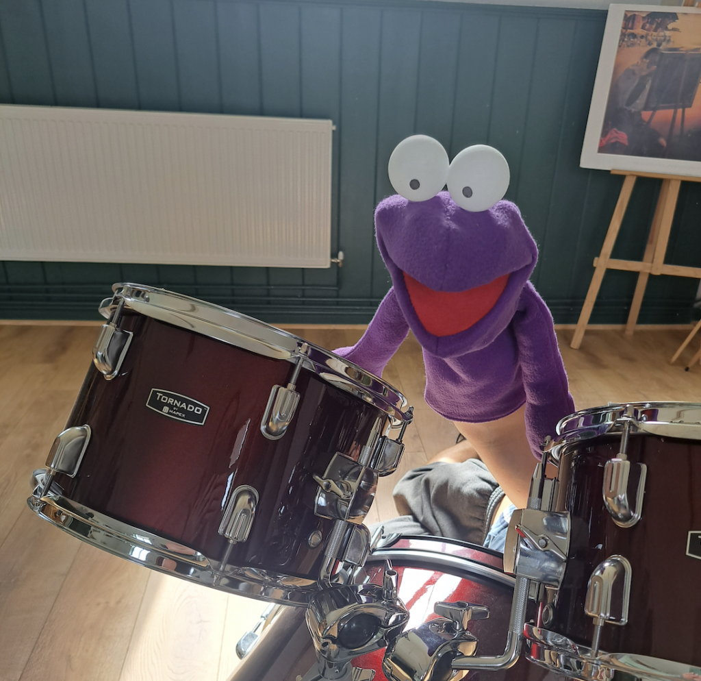A puppet of a frog playing the drums